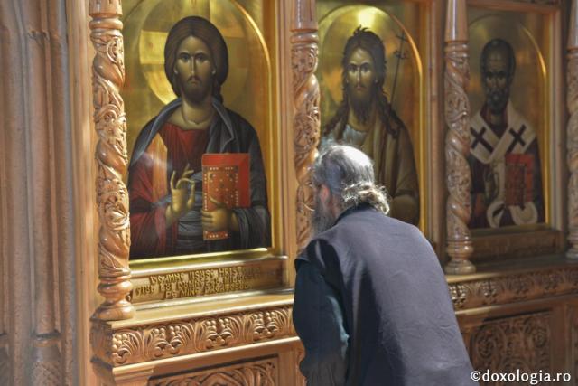 călugăr în fața icoanei Mântuitorului Hristos