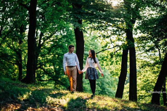cuplu ținându-se de mână în pădure