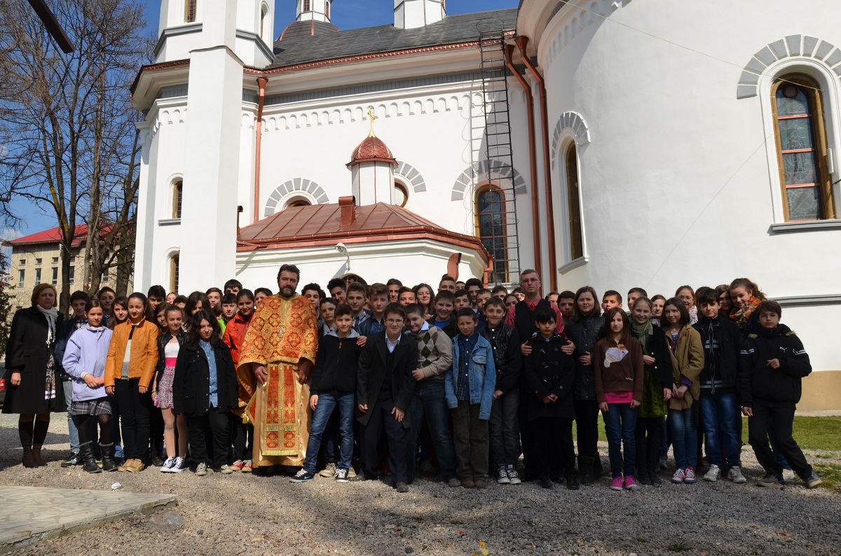 Părintele paroh Ilie Macar, alături de o parte din elevii și profesorii implicați în proiectul „Hristos împărtăşit copiilor“/ Foto: Tudorel Rusu 72 de elevi au dat răspunsurile liturgice la Biserica „Sfântul Nicolae“ din Câmpulung Moldovenesc
