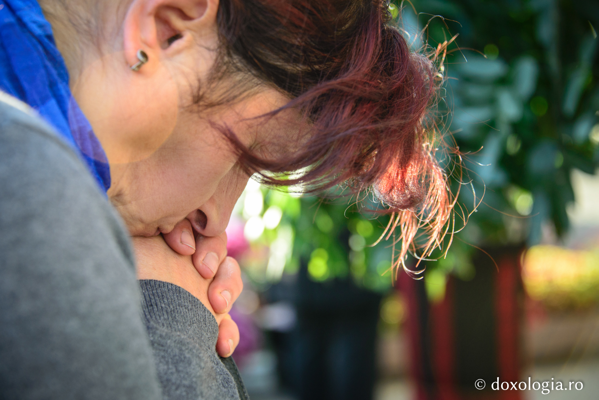 femeie sprijinindu-și capul în mâini