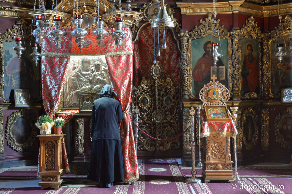 femeie în fața icoanei Sfintei Ana