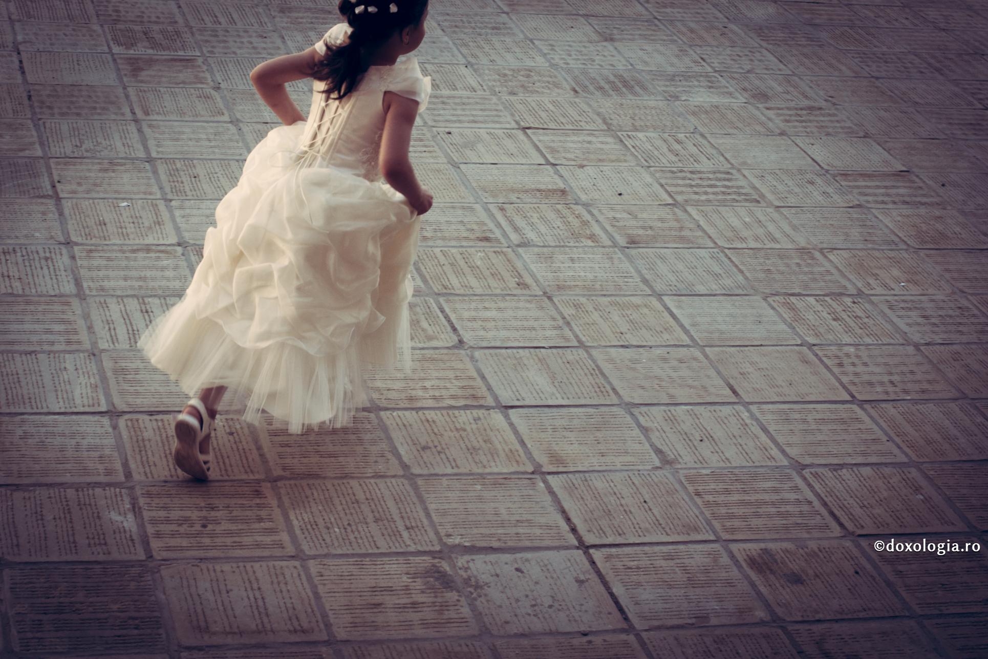 copilă în rochiță alergând