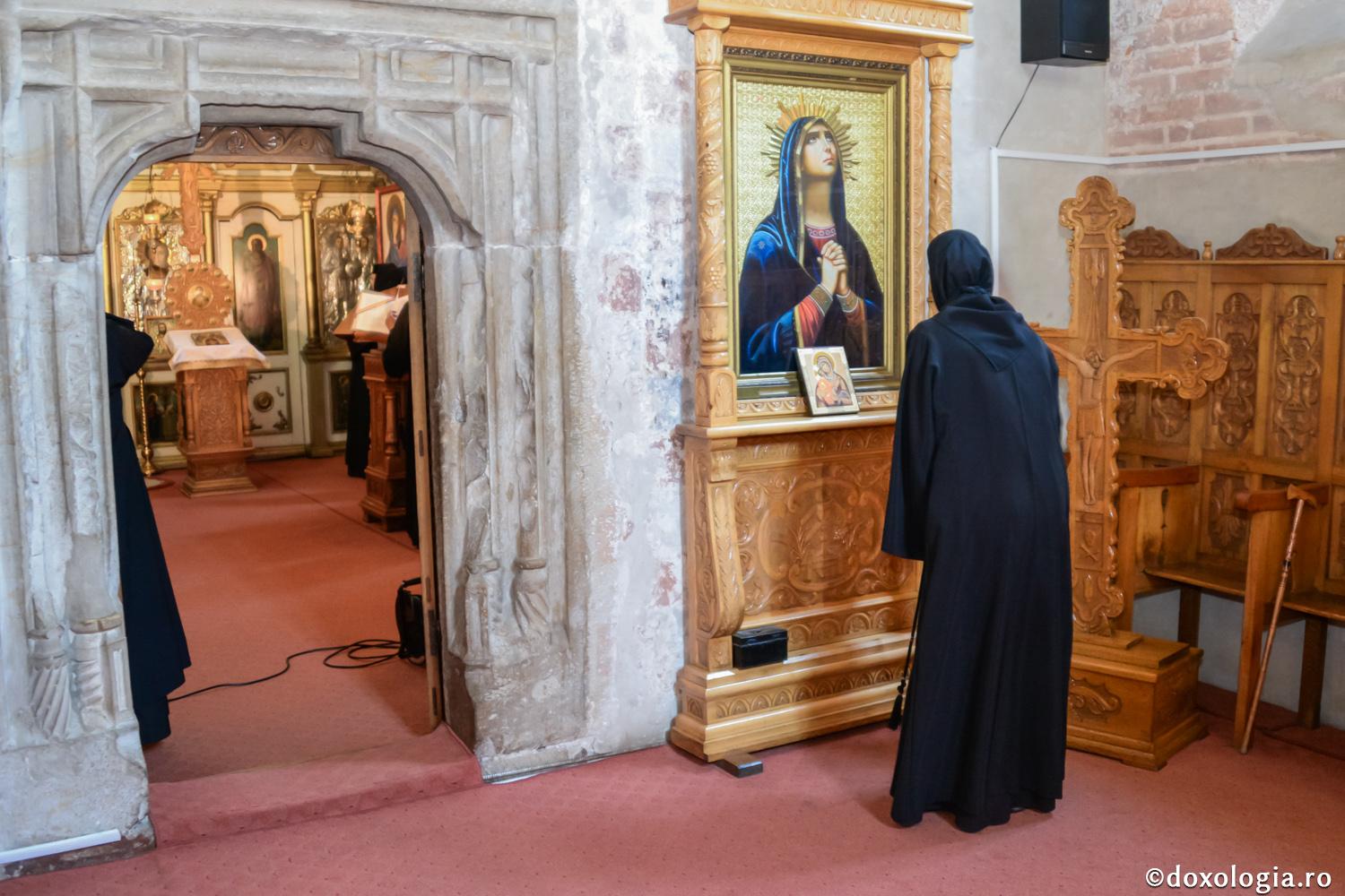 maică închinându-se la icoana Maicii Domnului