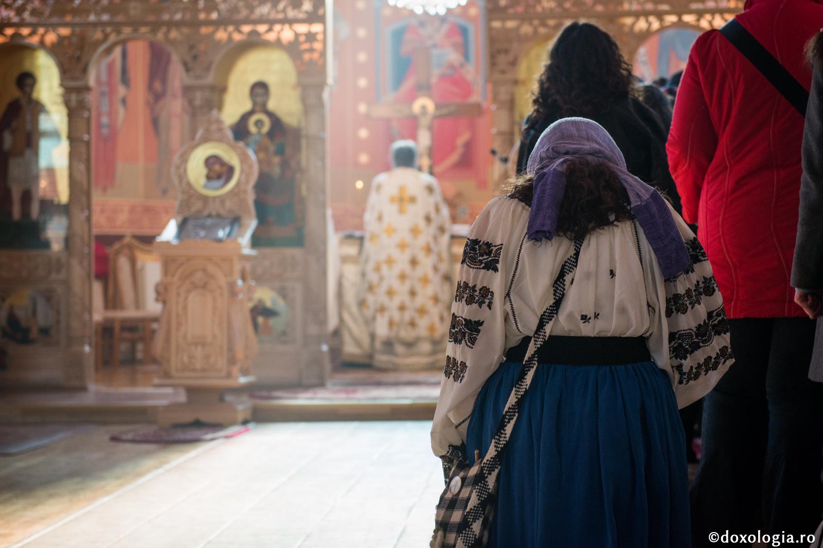În timpul Liturghiei, cu toții ne aflăm în fața Preasfintei Treimi / Foto: Oana Nechifor femeie participând la slujbă