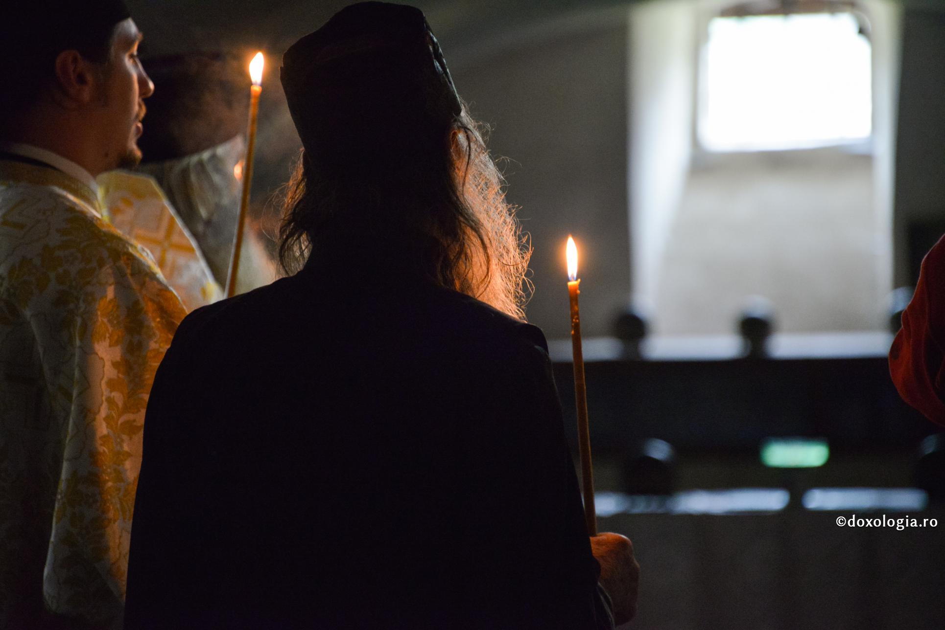călugăr cu lumânare aprinsă în mână