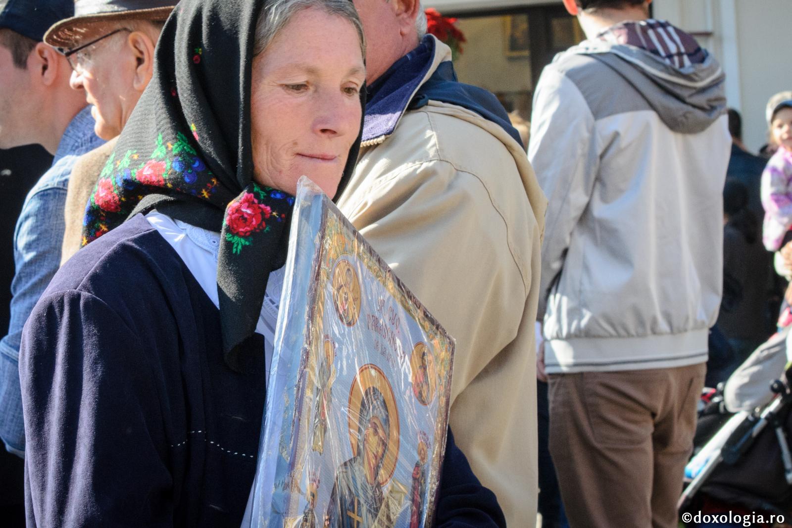 femeie cu icoană în brațe