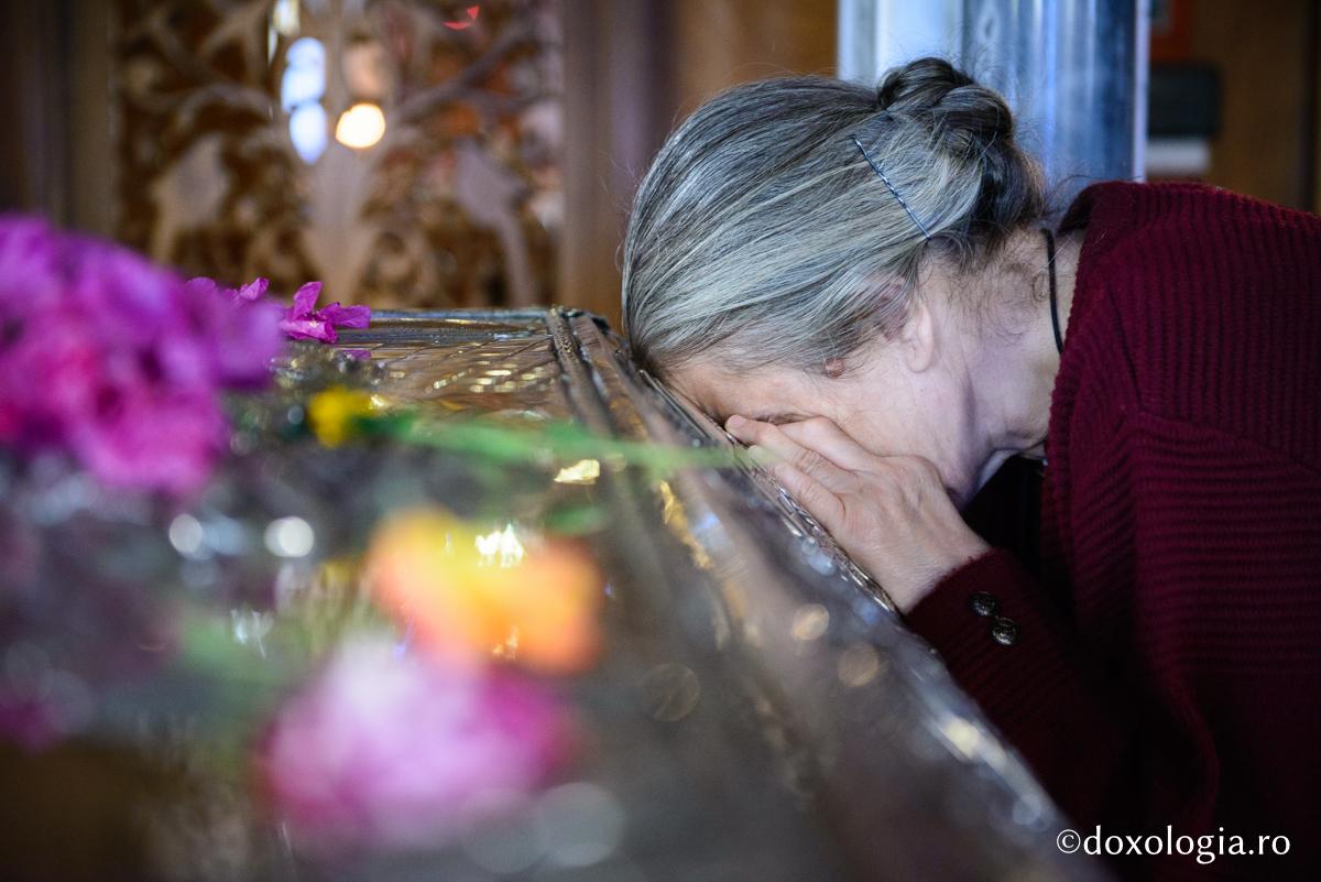 femeie rugându-se la raclă