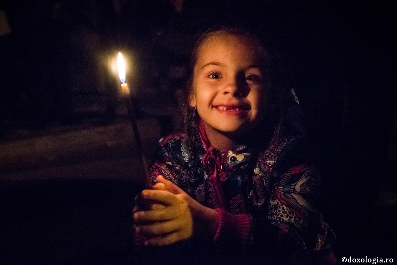 copilă cu lumânări aprinse în mână