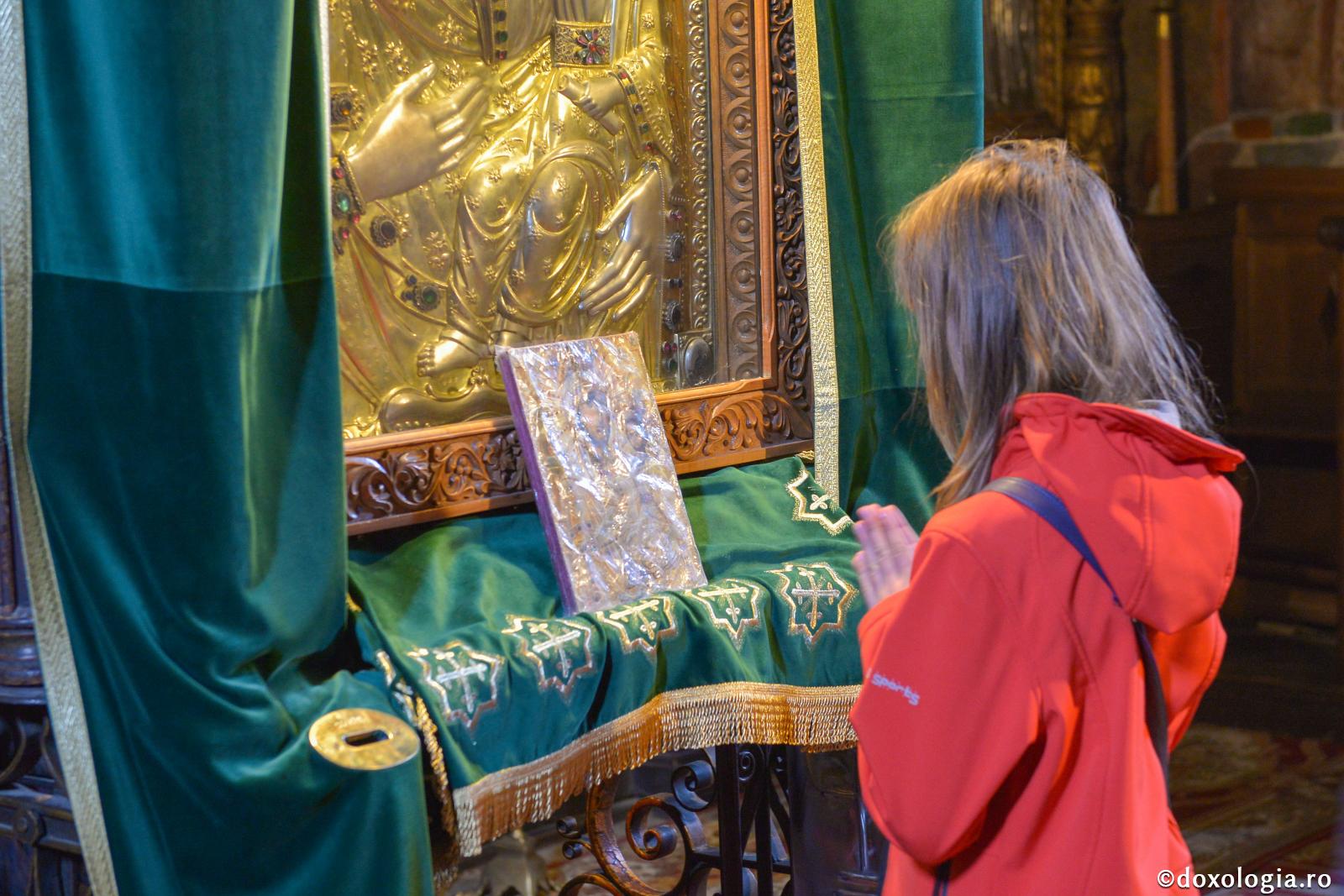 copil rugându-se în fața icoanei Maicii Domnului