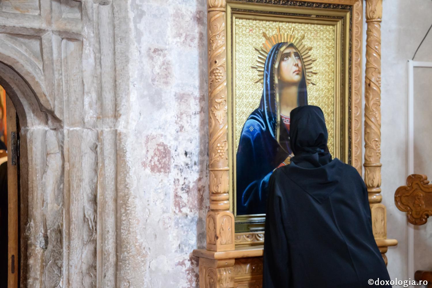 maică închinându-se la icoana Maicii Domnului