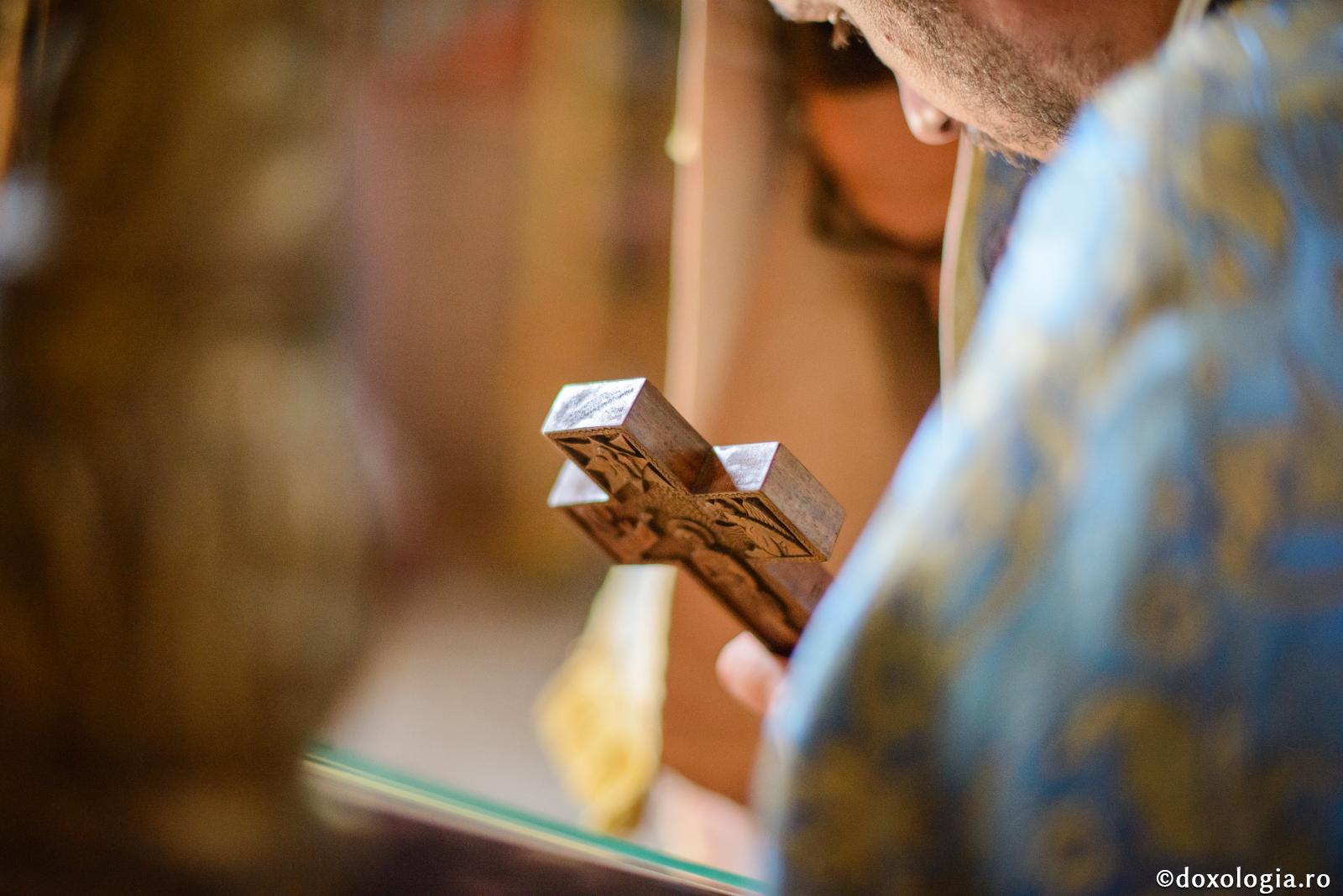 preot cu crucea în mână