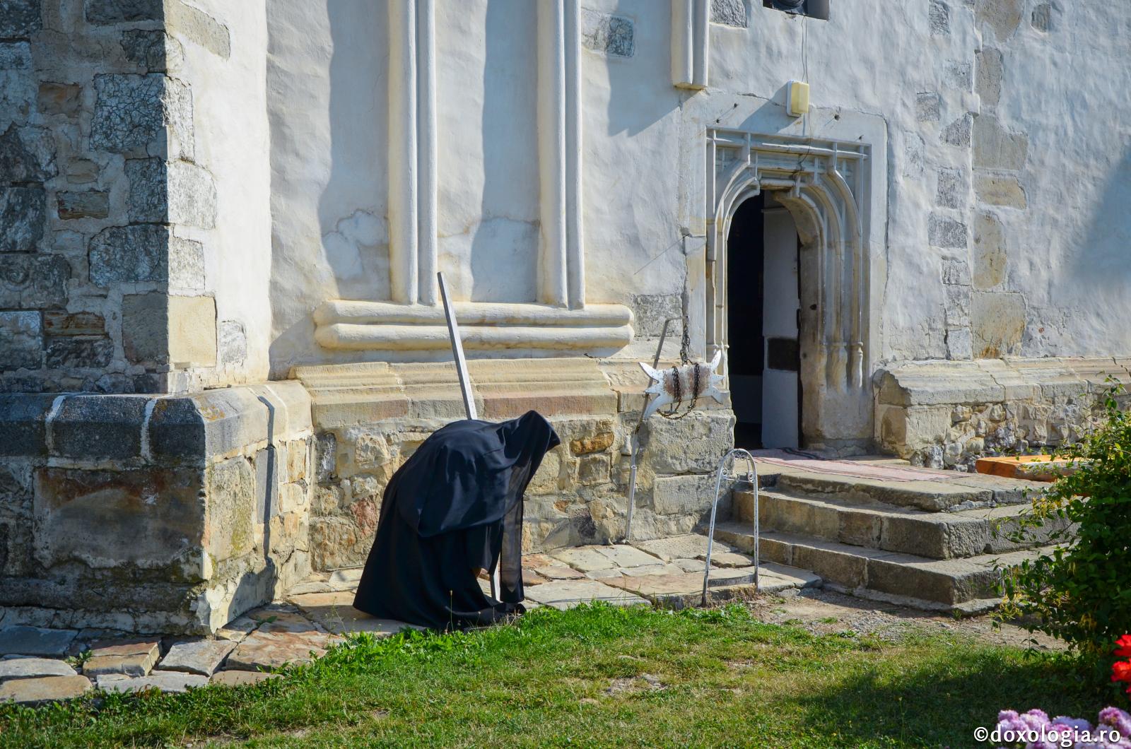 Monahul Evghenie Dumitrescu – 40 de ani în slujba lui Hristos și a oamenilor / Foto: Maria Burlă călugăr închinându-se în timp ce bate toaca mică