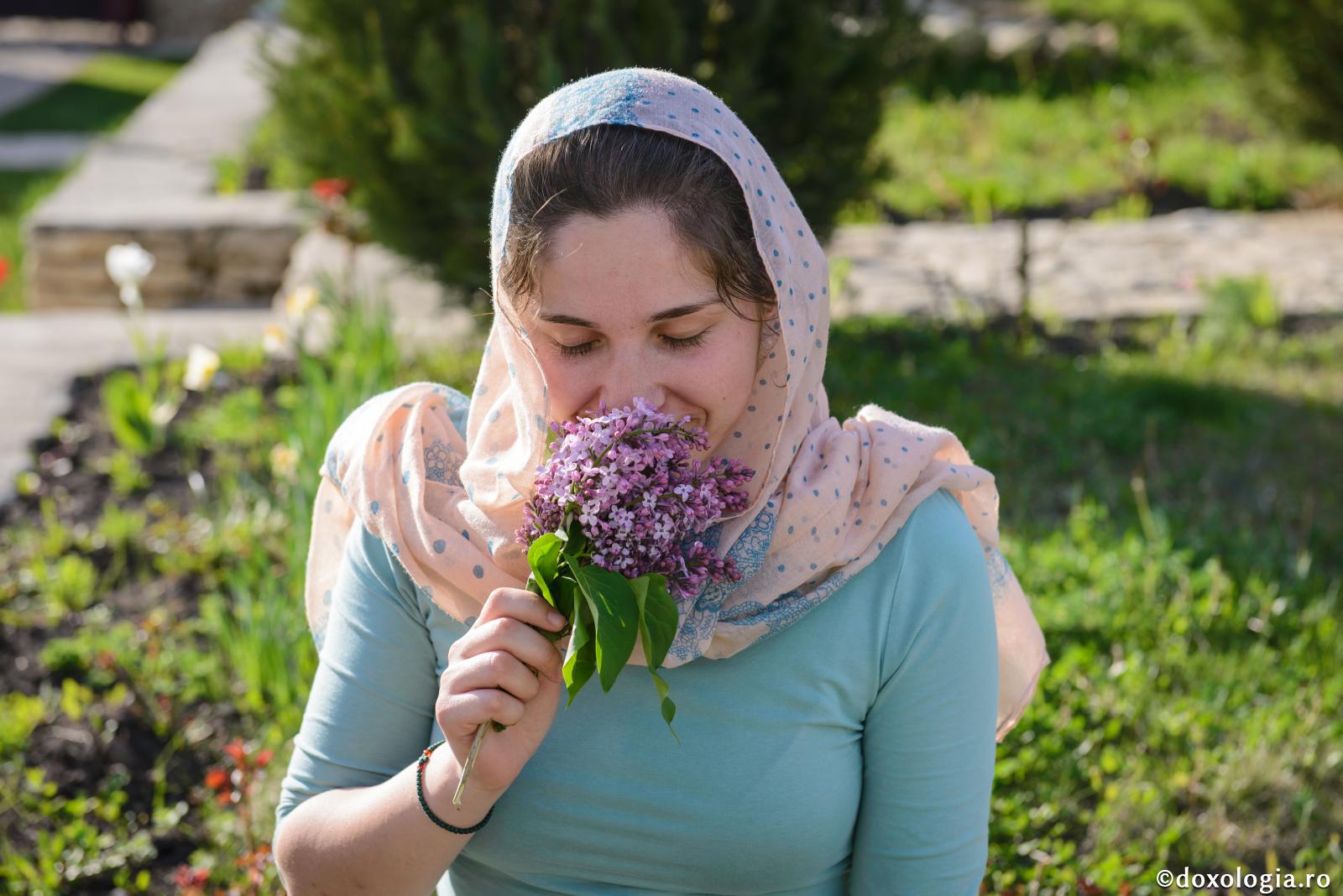 tânără mirosind flori de liliac