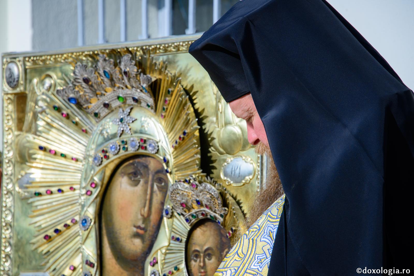 preot în fața icoanei Maicii Domnului
