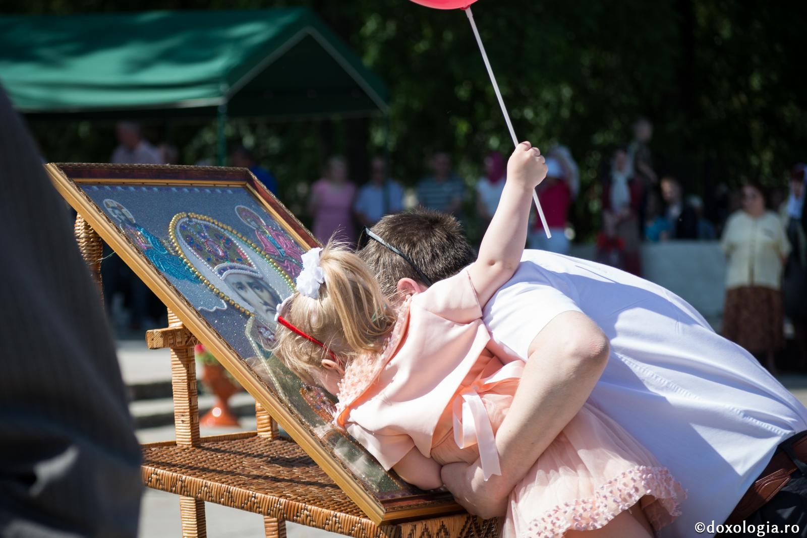 O întâmplare despre ocrotirea minunată a Sfântului Nicolae / Foto: Oana Nechifor tată și fiică sărutând icoana Sfântului Nicolae