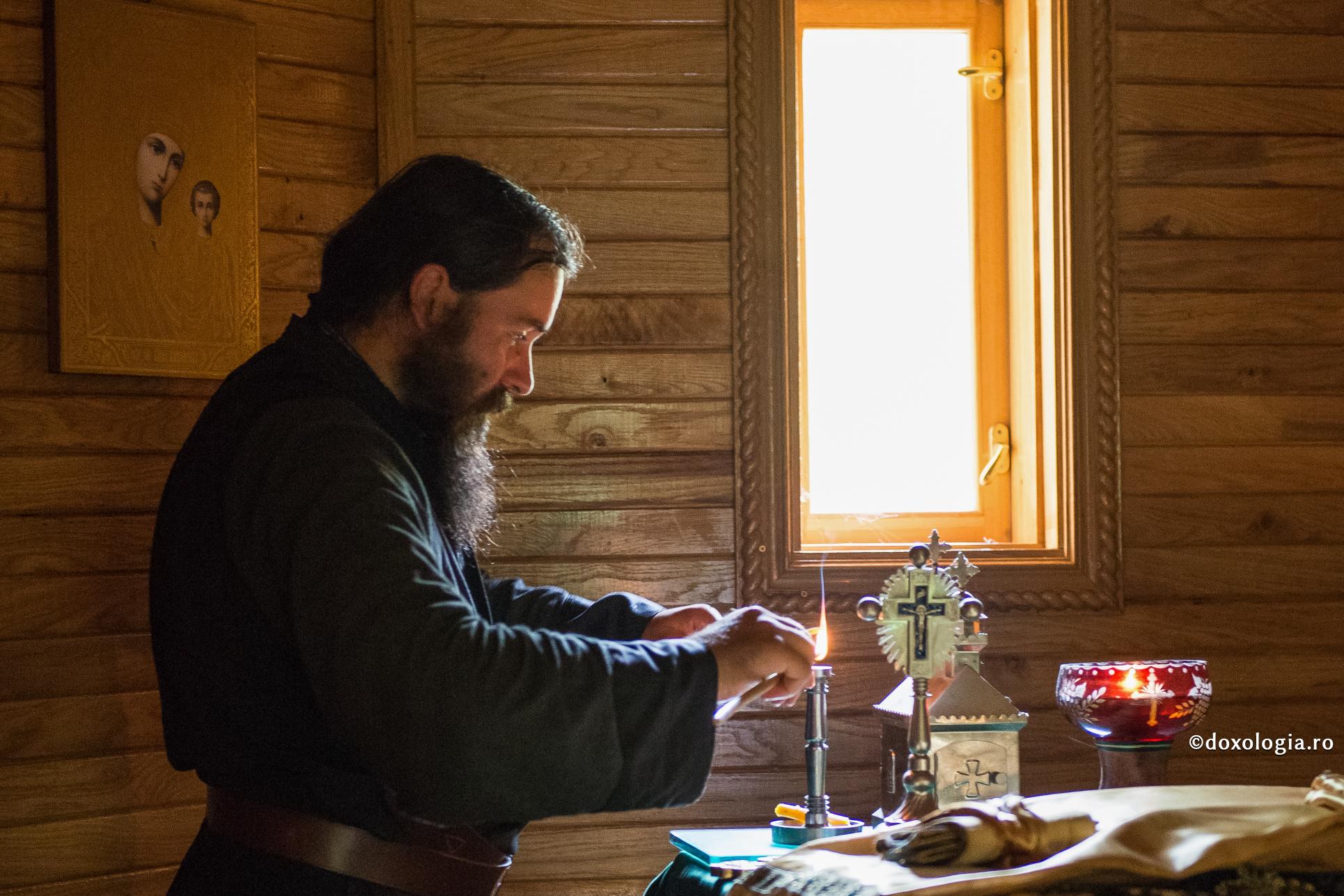 călugăr schimbând lumânarea în sfeșnic