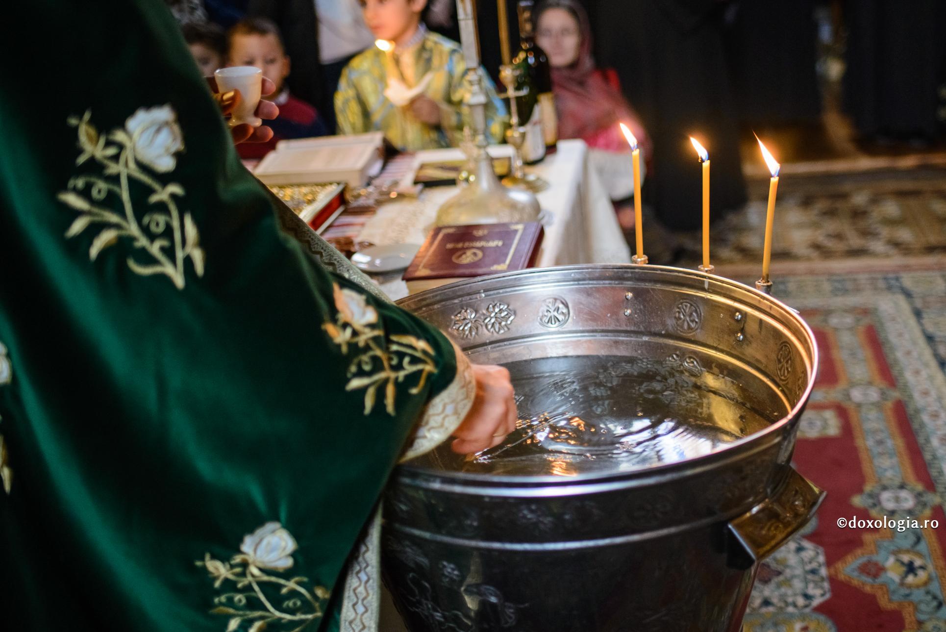 Botezul, haina pe care o purtăm și ne poartă / Foto: Oana Nechifor preot binecuvântând apa din cristelniță
