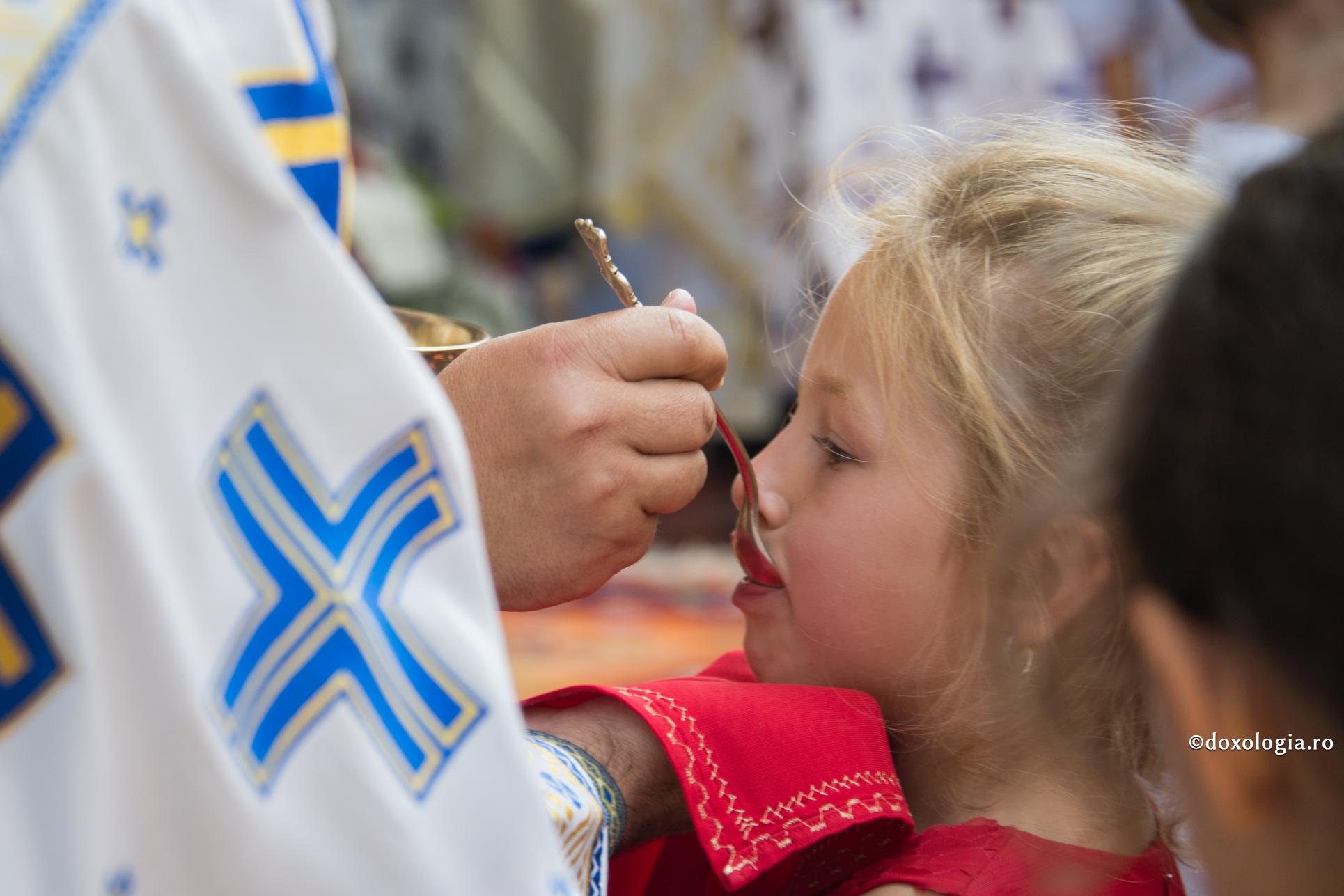 Sufletul copilului nu va putea uita niciodată deasa unire cu Hristos prin împărtășanie / Foto: Oana Nechifor preot împărtășind un copil