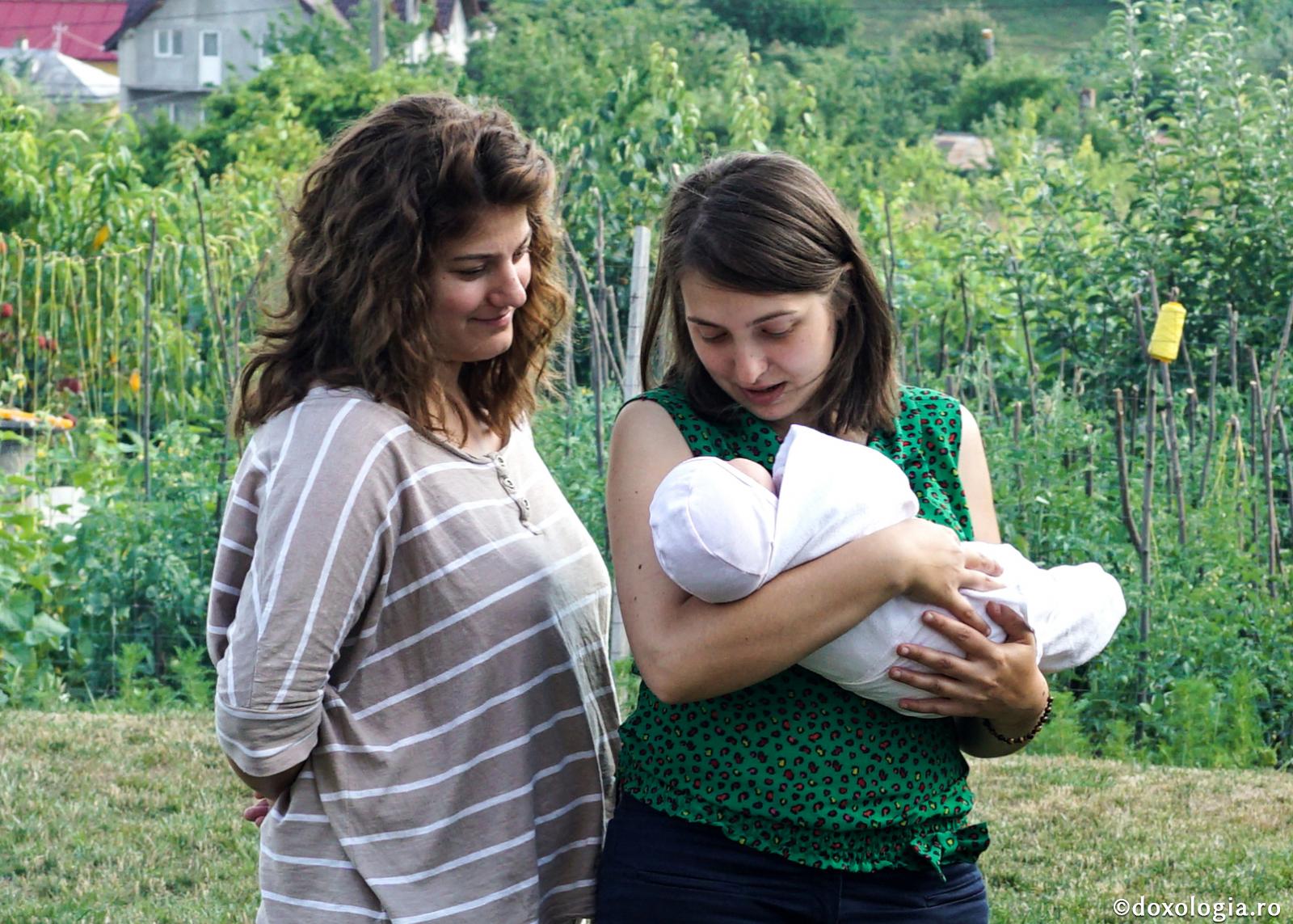femeie cu prunc în brațe