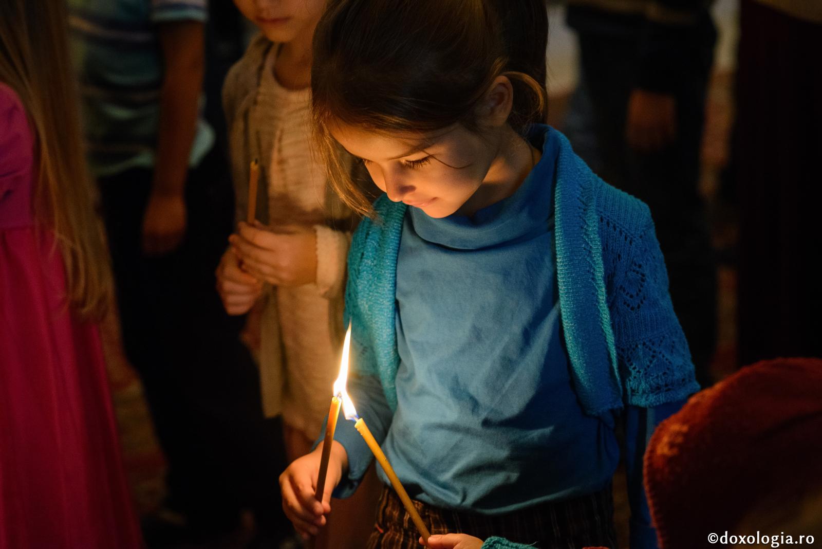 copilă cu lumânări aprinse în mână