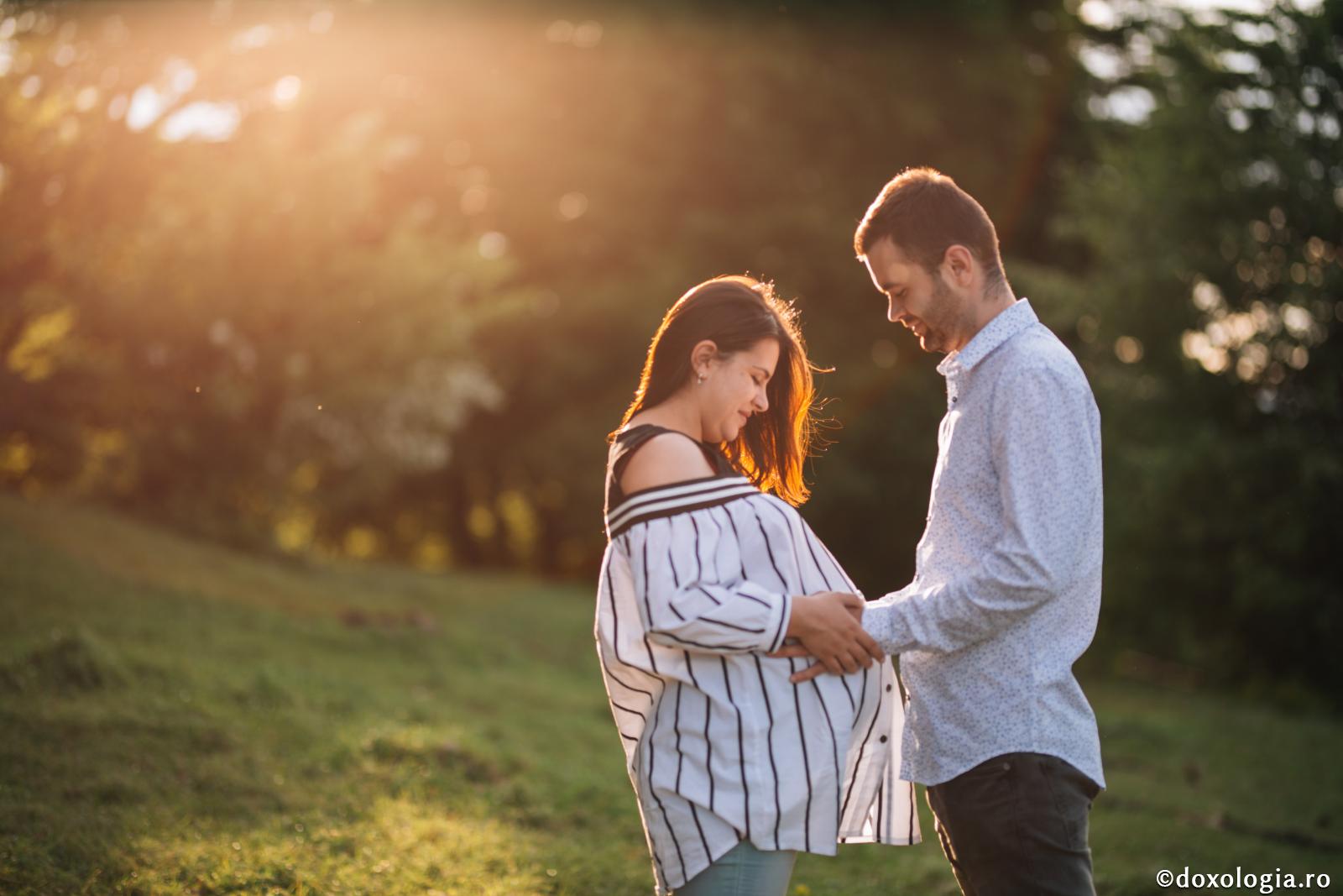 bărbat ținând mâna pe burta femeii însărcinate