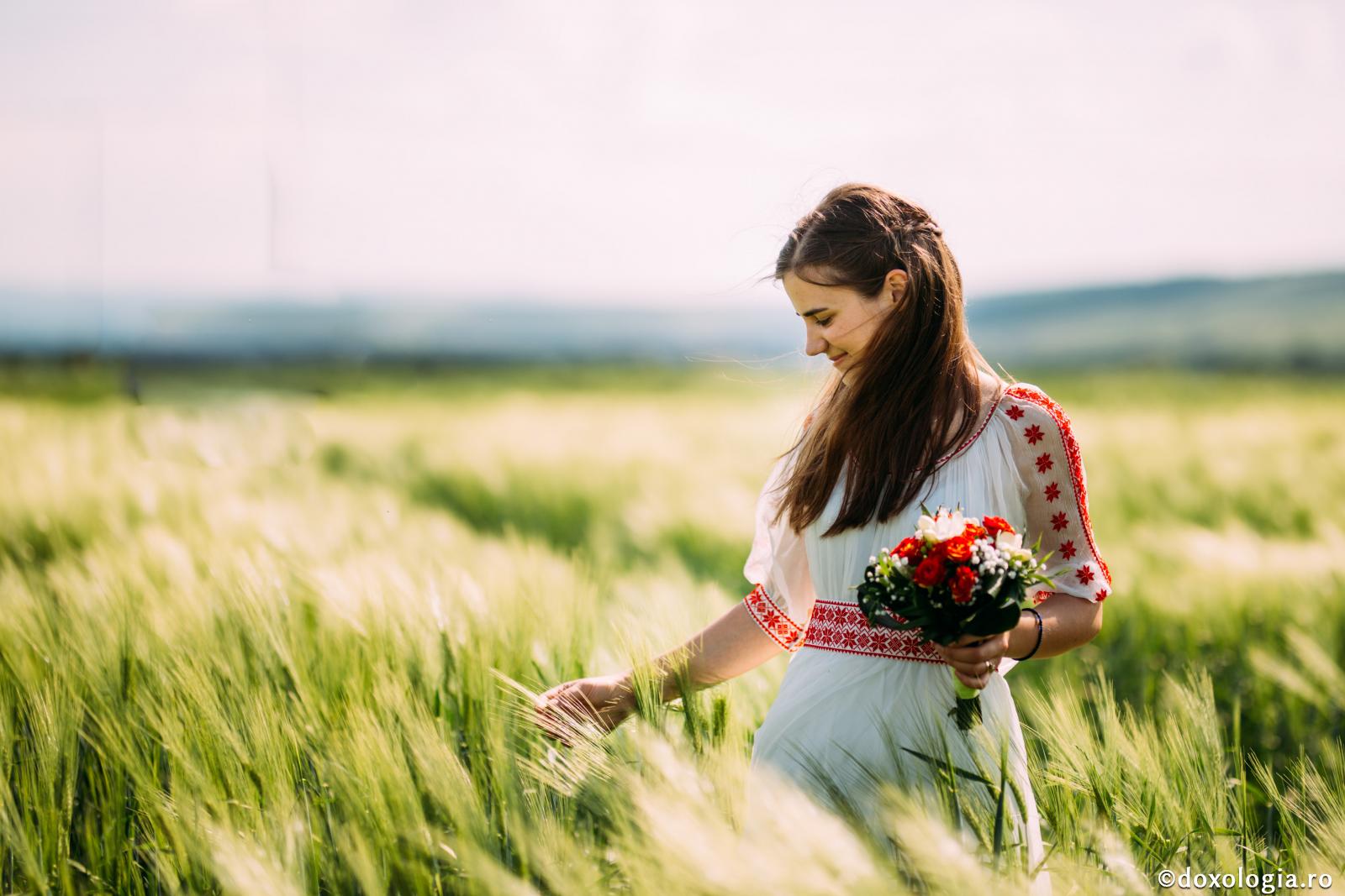 femeie cu buchet de flori în mână în lan
