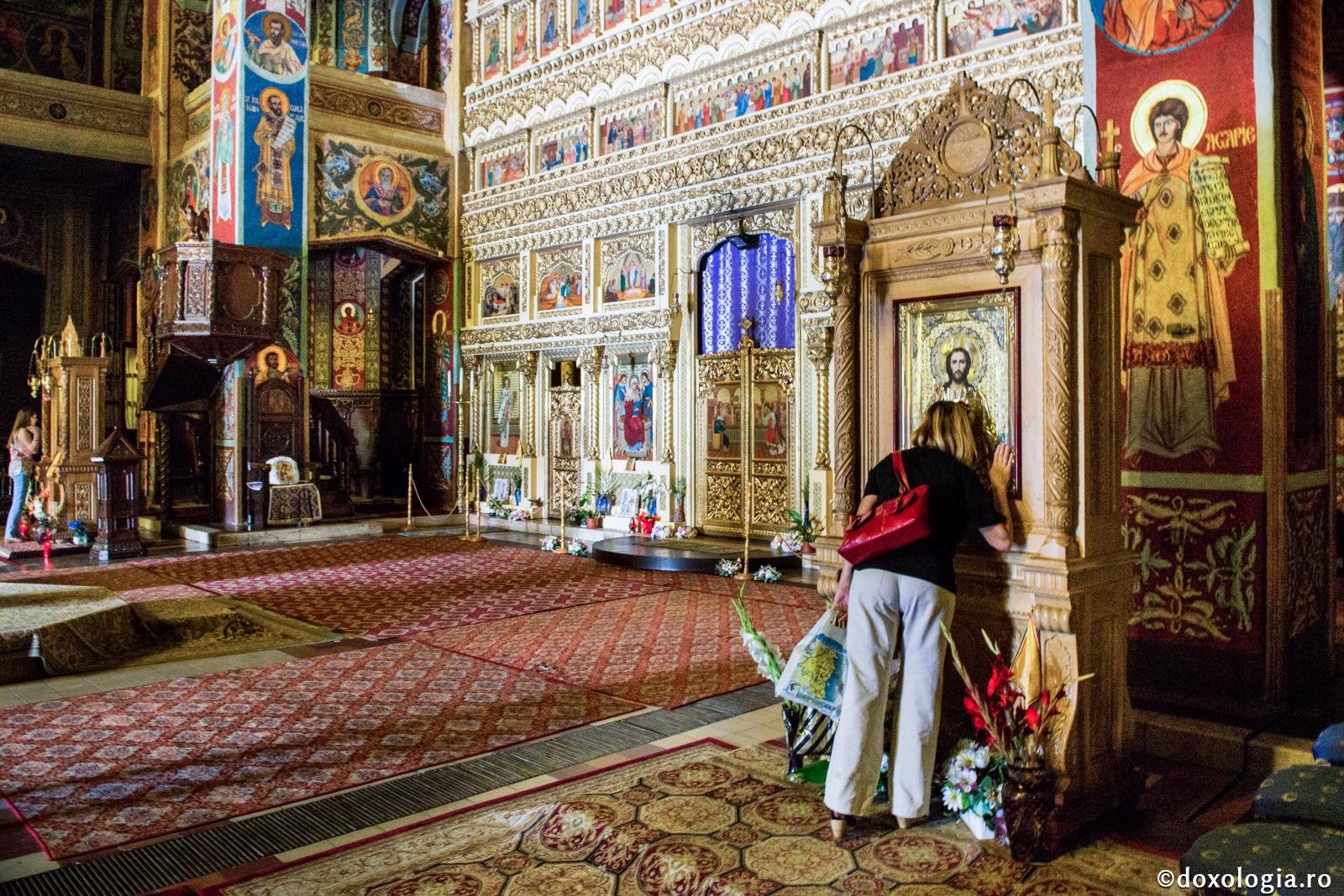 femeie închinându-se la icoana Mântuitorului Hristos