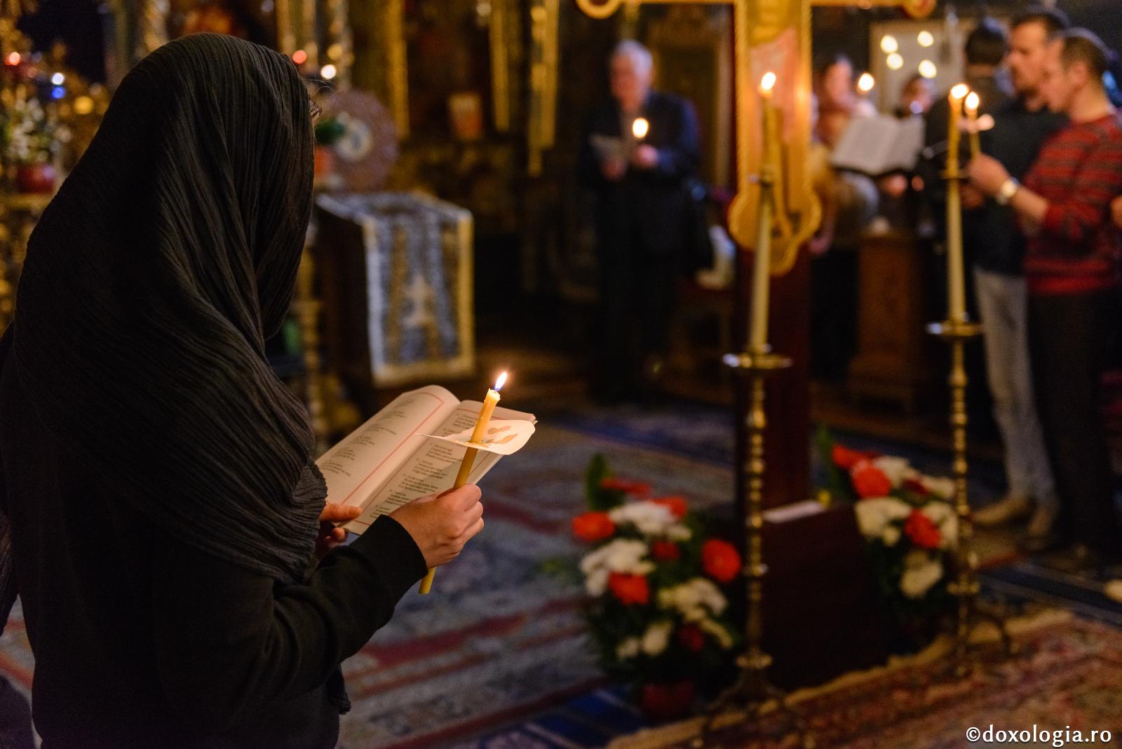 femeie cântând Prohodul Domnului în biserică