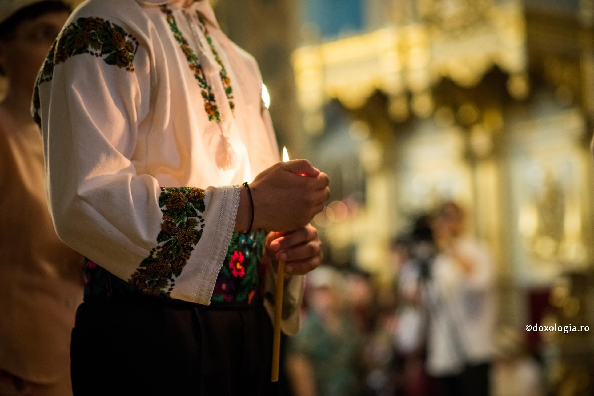 bărbat în costum popular cu lumânarea aprinsă