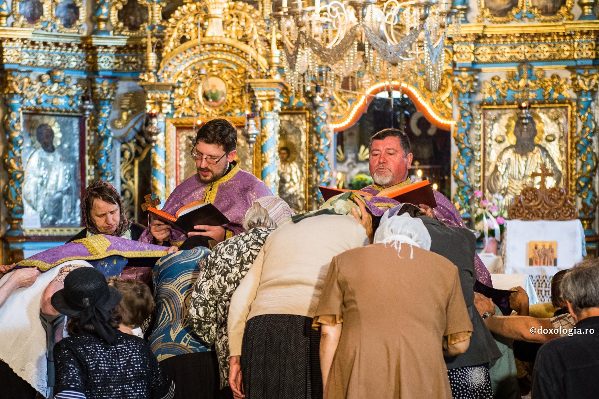 preoți citind rugăciuni peste credincioși