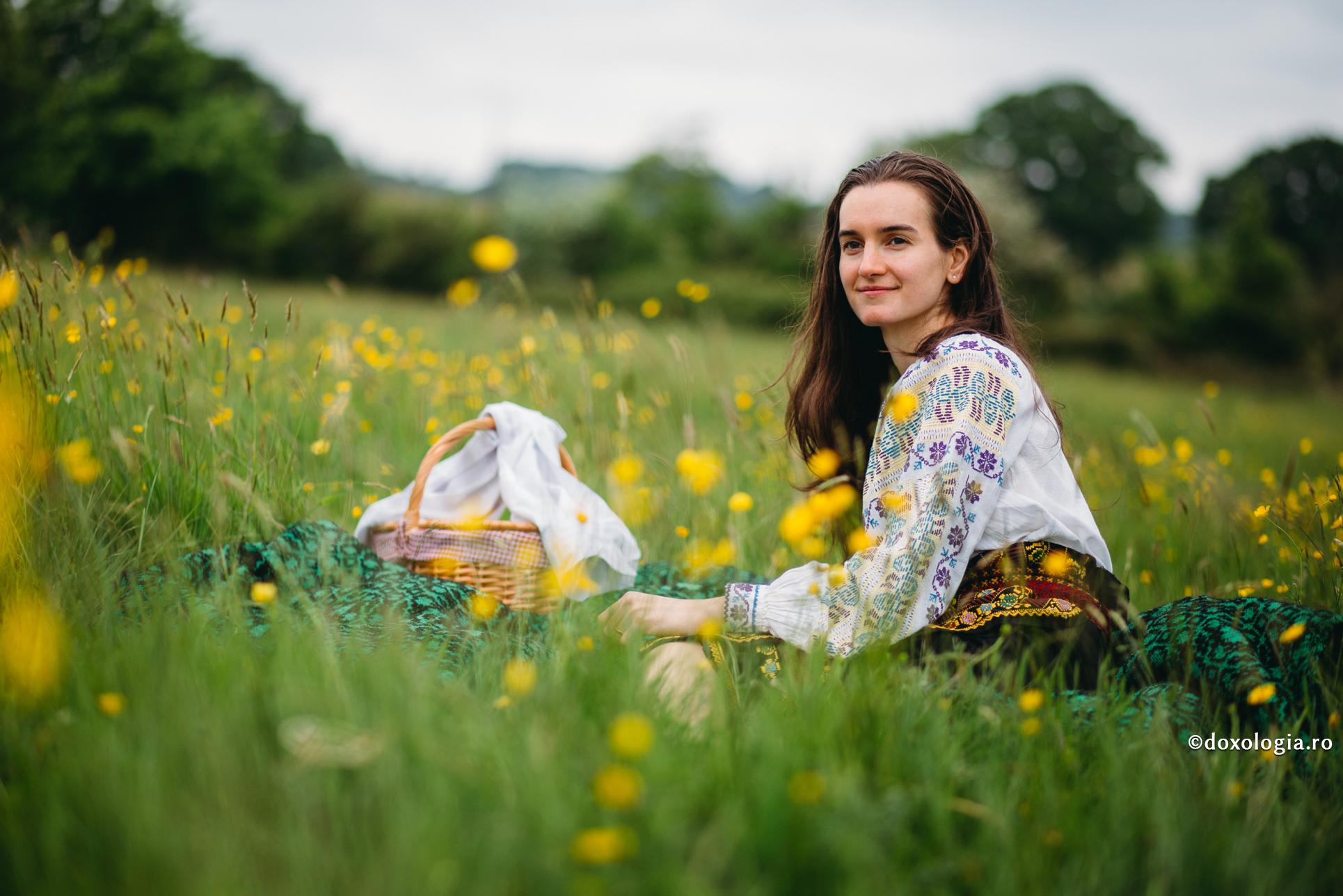 tânără în costum popular pe pajiște