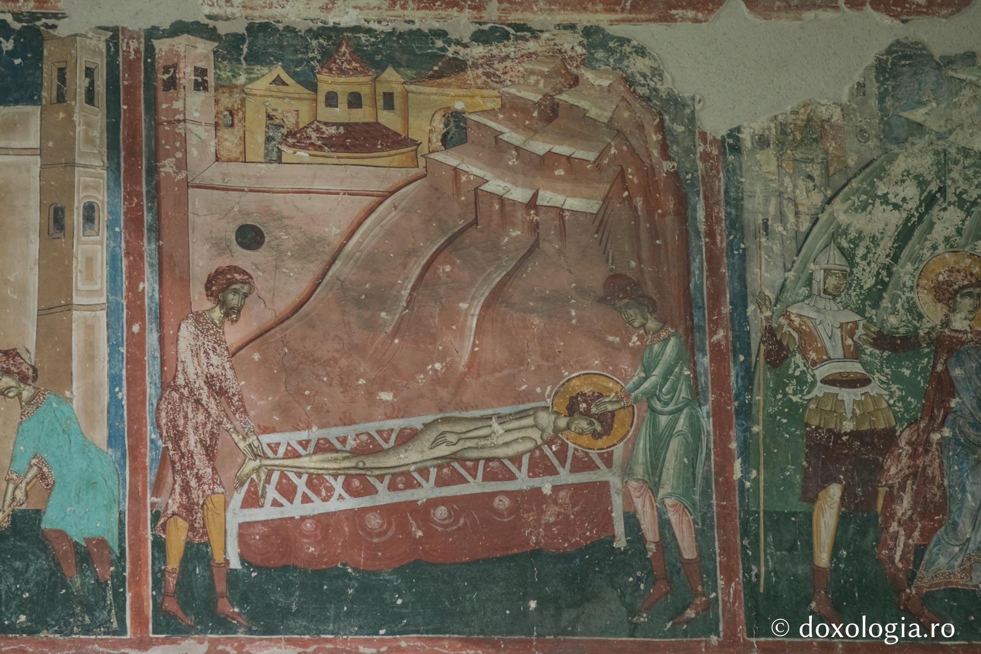 Sfântul Gheorghe este așezat pe un pat de fier înroșit – Reprezentare iconografică pe peretele exterior de vest al bisericii Arbore / Foto: Pr. Silviu Cluci Sfântul Gheorghe este așezat pe un pat de fier înroșit