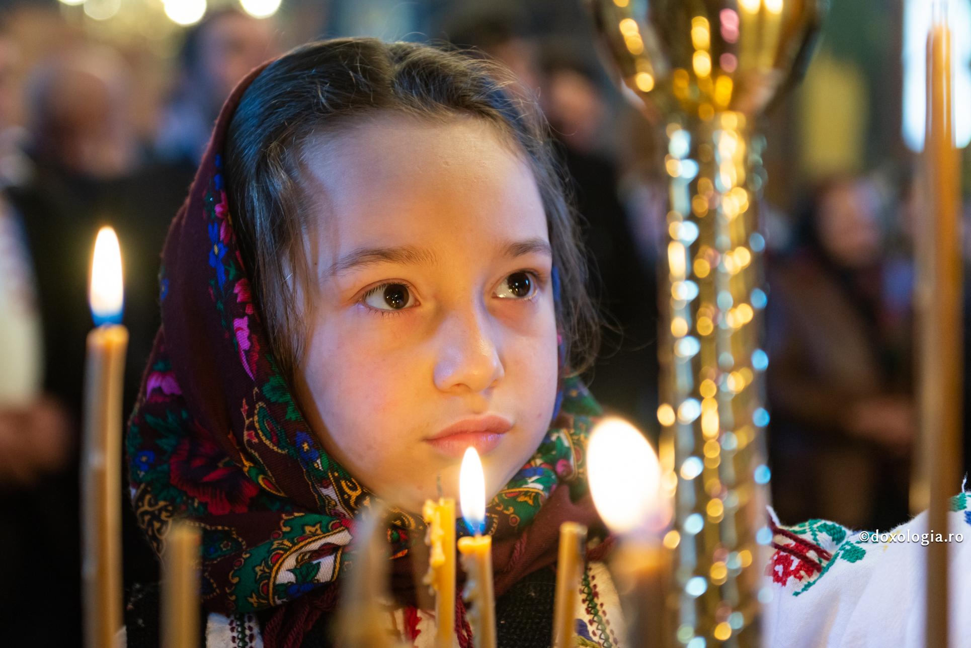 fetiță aprinzând lumânarea