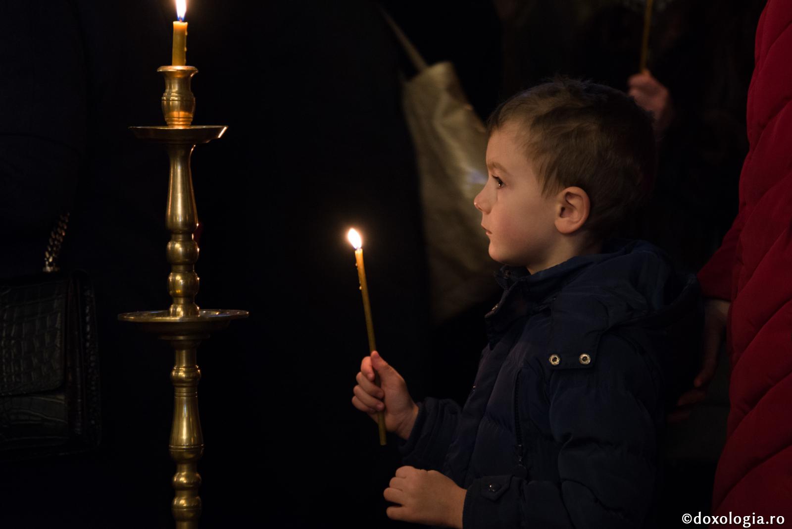 copil cu lumânare aprinsă în mână