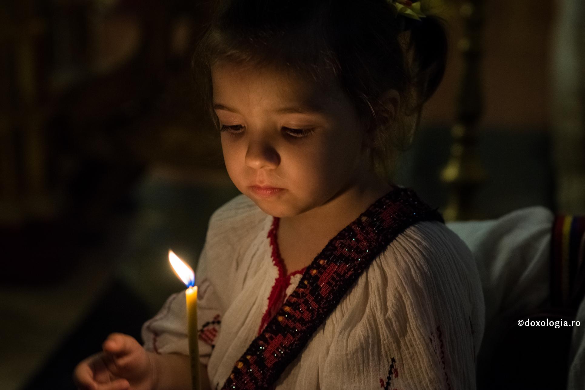 „Secretele” copiilor cu Dumnezeu – experiența personală a credinței / Foto: Oana Nechifor fetiță cu lumânare aprinsă în mână