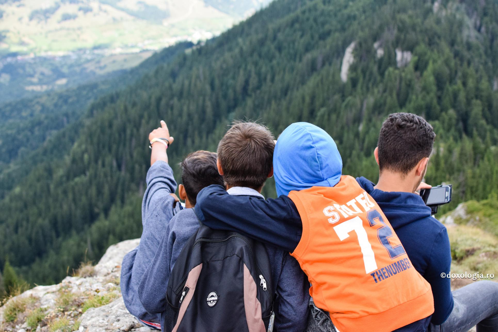 tineri pe vârful muntelui privind în zare