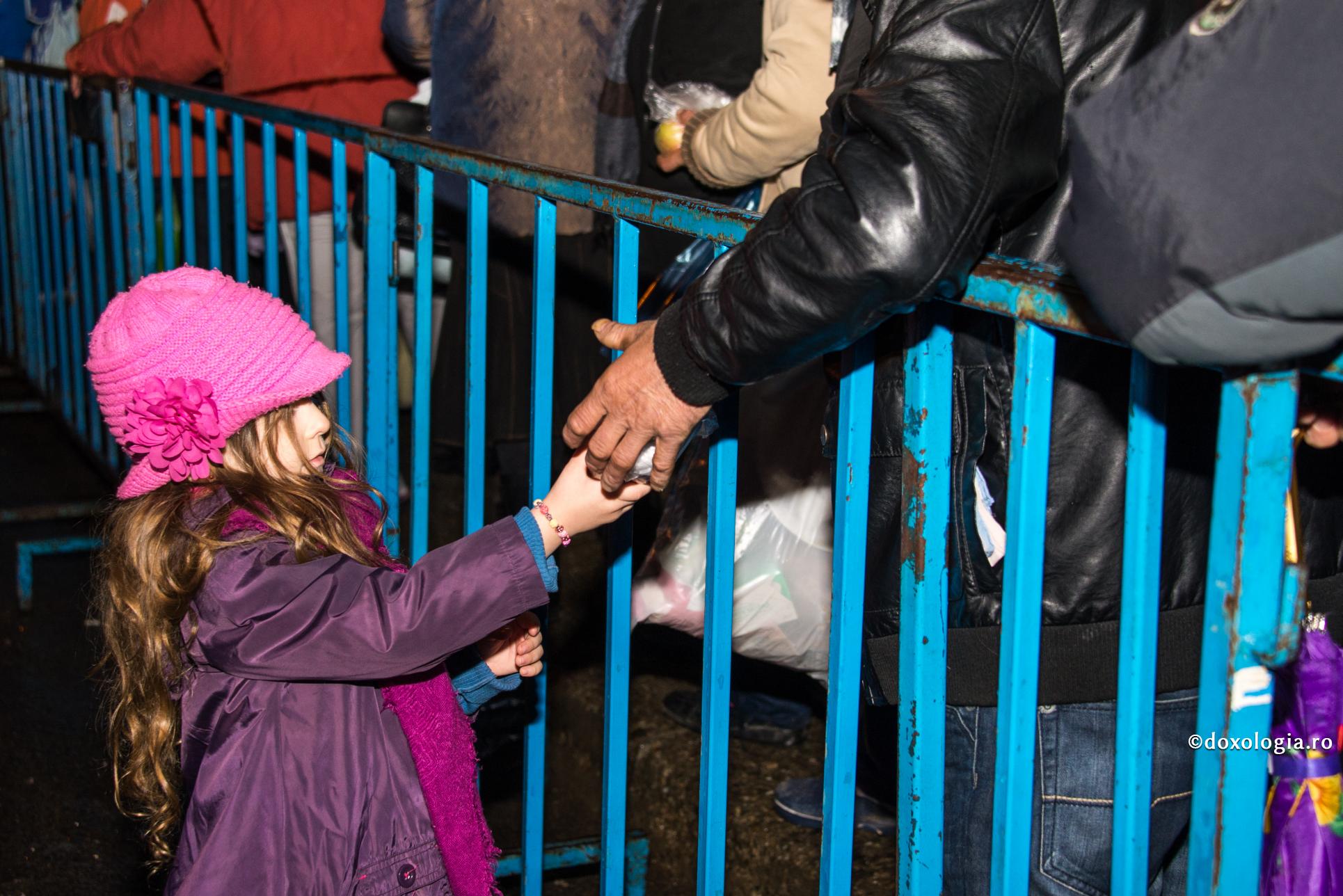 A învăța să împartă cu alții poate fi o sarcină dificilă pentru copil / Foto: Oana Nechifor fetiță dăruind un pachet