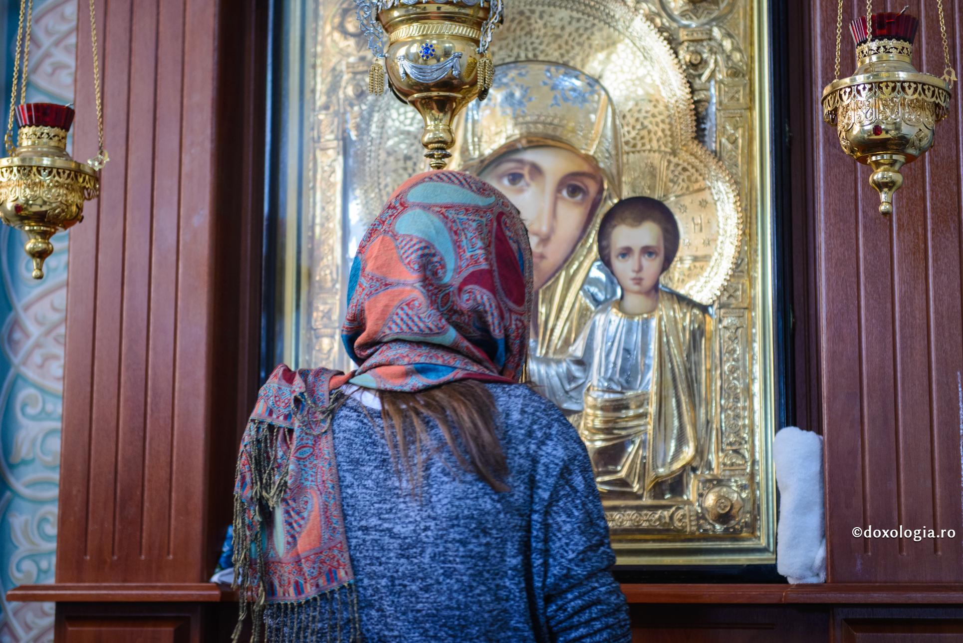 femeie în fața icoane Maicii Domnului