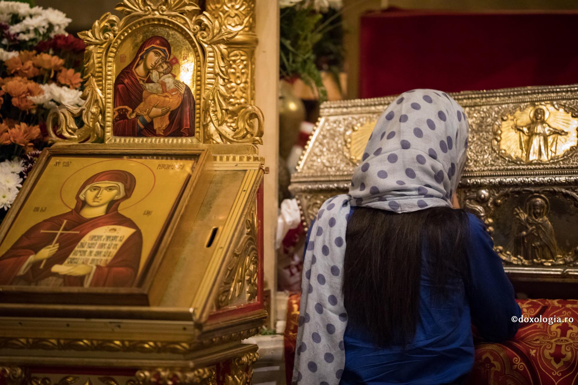 femeie rugându-se la racla Sfintei Cuvioase Parascheva