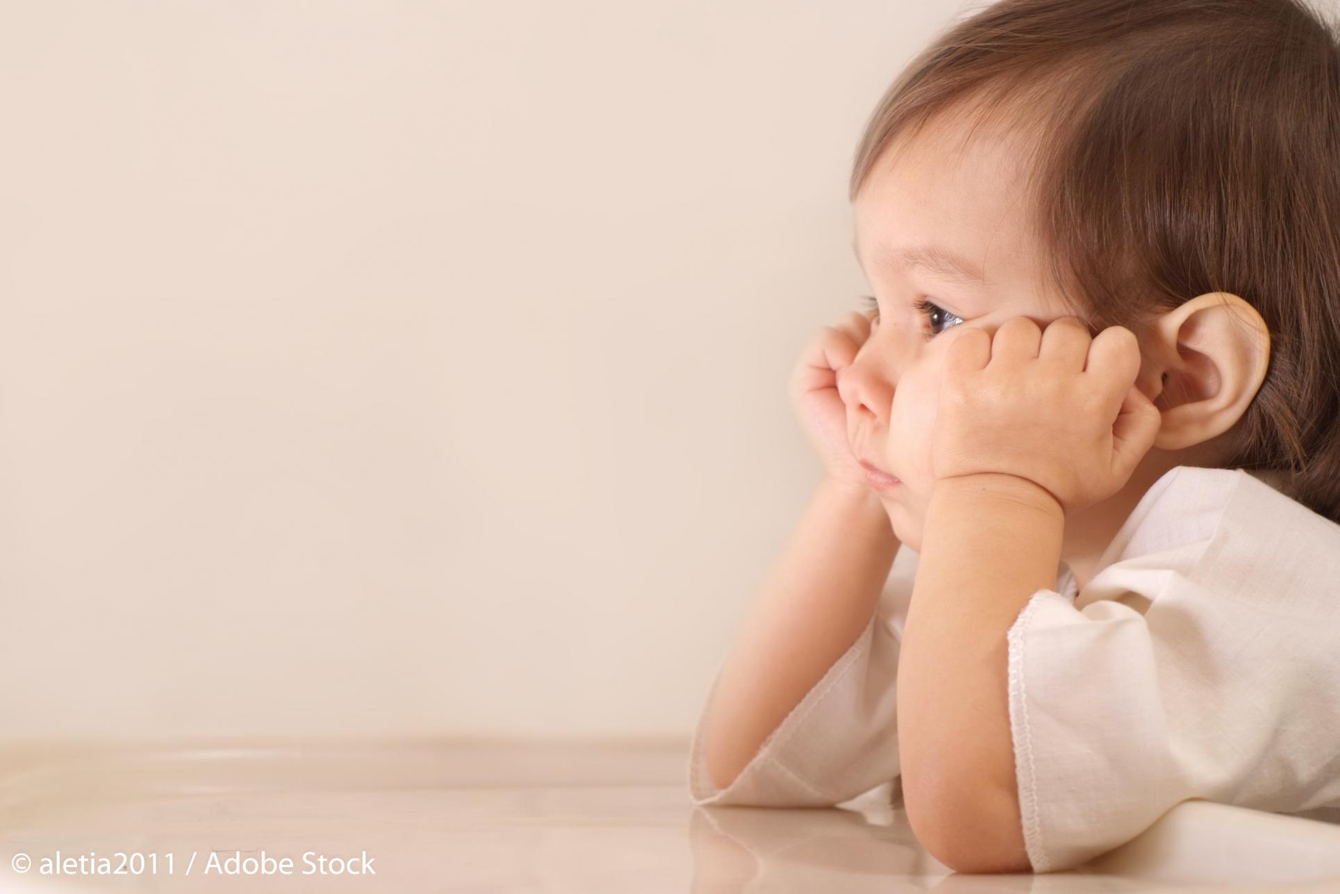 Nu împovăra copilul cu problemele tale de adult! / Foto: aletia2011, AdobeStock copil stând cu capul între mâini