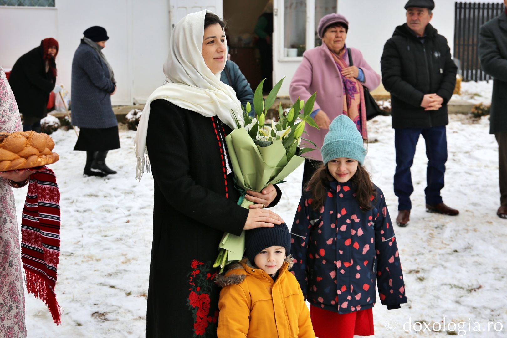 Familia preotului paroh întâmpinându-l pe Părintele Mitropolit Teofan la Budești / Foto: Flavius Popa credincioși cu copii de mână