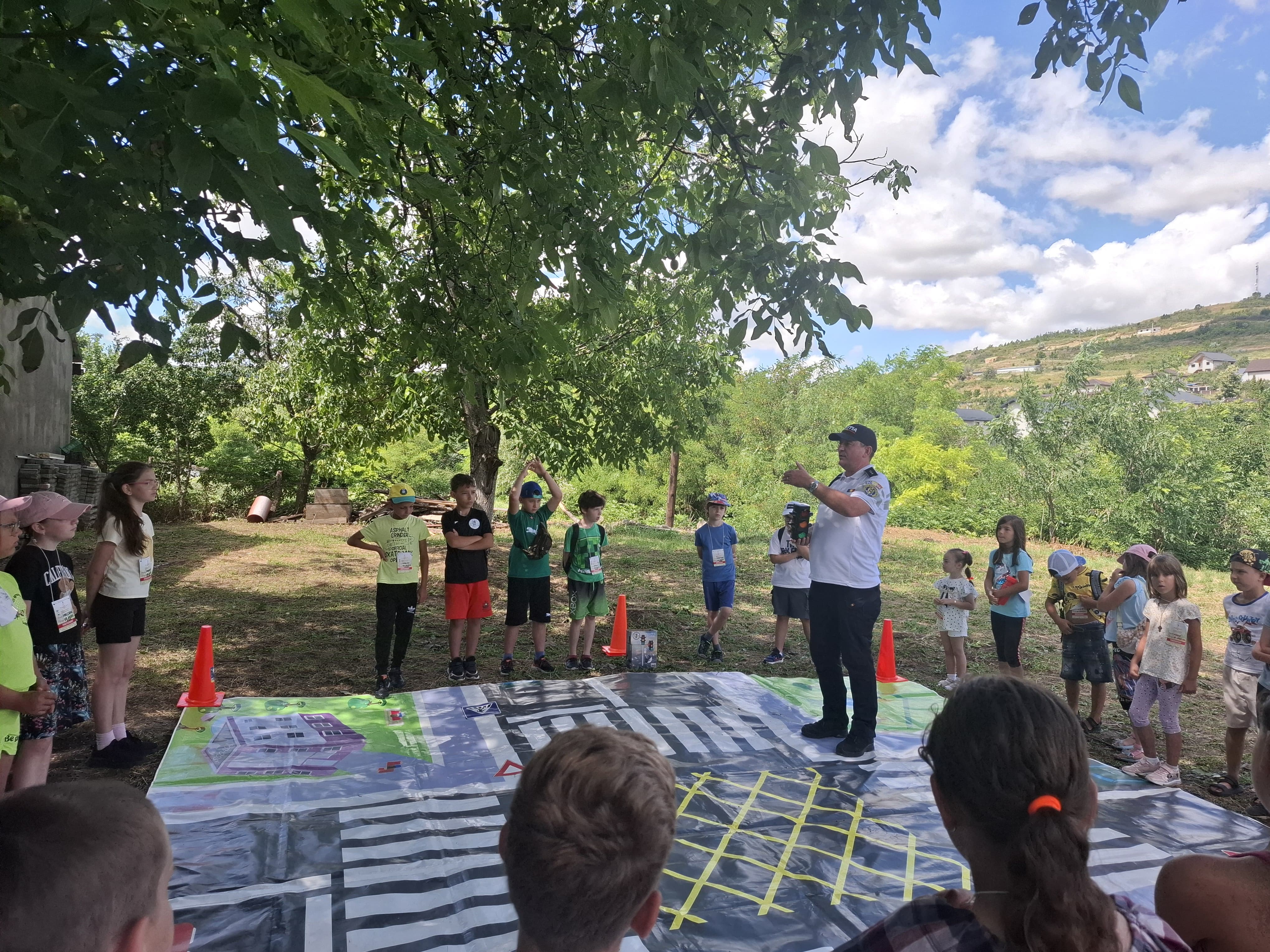 Polițiștii și reprezentanții Agenției Împotriva Traficului de Persoane din Iași, alături de copiii din taberele de vară