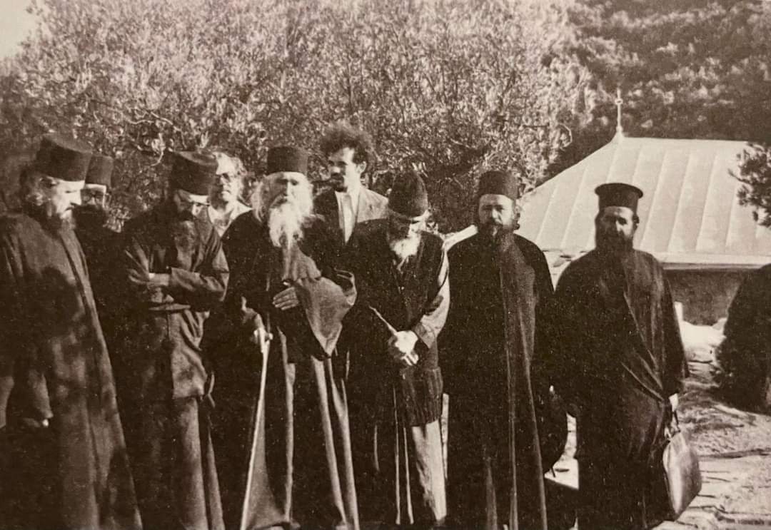 De la stânga la dreapta: Arhimandritul Bartolomeu Florea, monah necunoscut, arhimandritul Vasile Gondikakis (starețul de atunci al mănăstirii Stavronikita), teologul Haralambos Nikiforidis (devenit arhimandrit în Mitropolia de Kerkyra, Paxon și insulele Diapontice), Cuviosul Cleopa Ilie, teologul Daniel Ciobotea (viitorul Patriarh al României, doctorand în anul 1977 la Strasbourg), Cuviosul Paisie Aghioritul, arhimandritul Victorin Oanele (starețul Mănăstirii Sihăstria), monahul Calinic Iviritul (care a ocupat funcția de protos al Muntelui Athos) Cuviosul Cleopa cu Sfântul Paisie Aghioritul