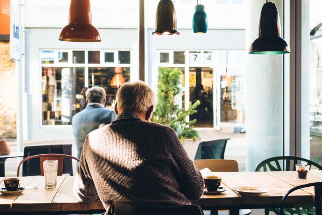 bătrân stând la o cafea