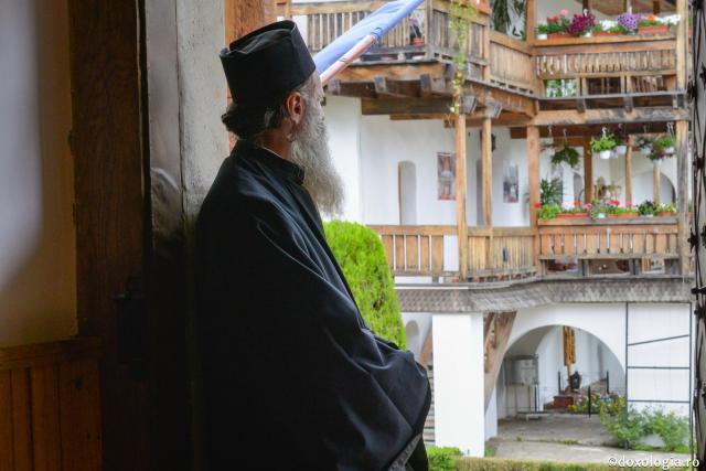 călugăr privind în curtea mănăstirii