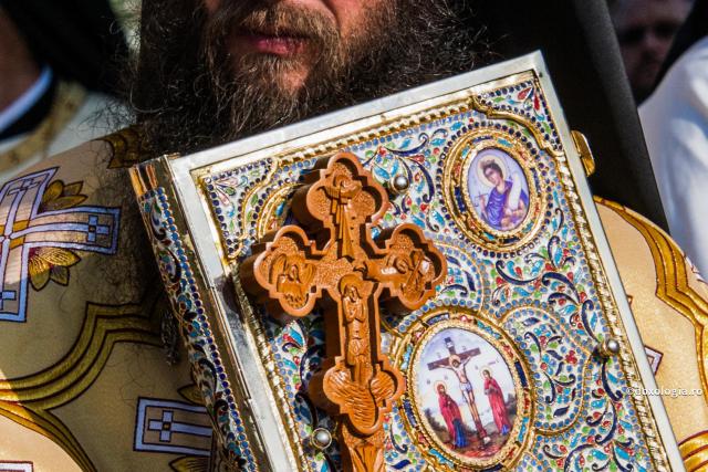 preot cu Crucea și Sfânta Evanghelie în mână
