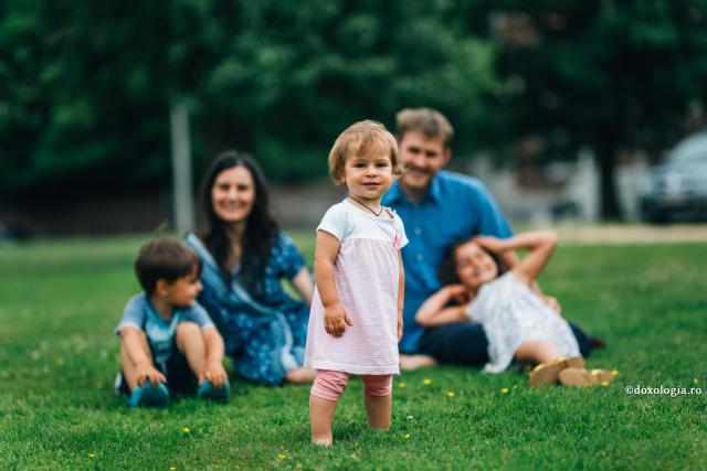 copilă alături de familie pe iarbă verde