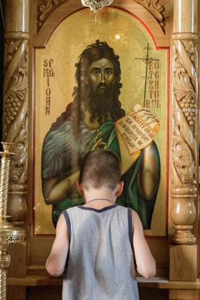 copil în fața icoanei Sfântului Ioan Botezătorul