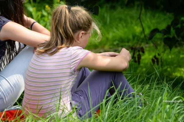copilă stând în iarbă