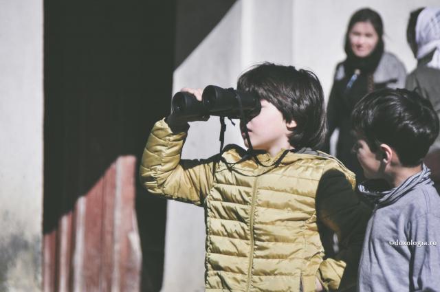 copil care se uita cu binoclul
